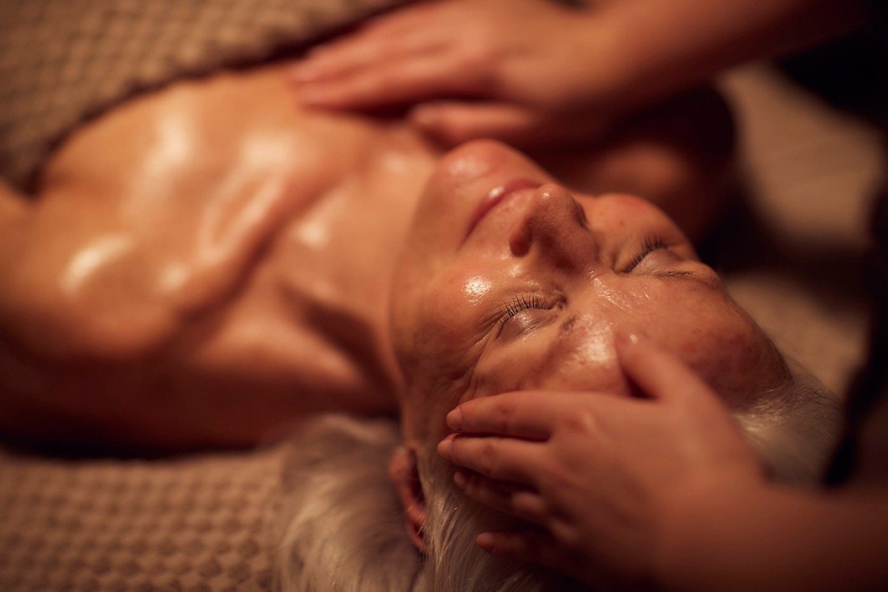 Spa therapist giving a woman a facial treatment.